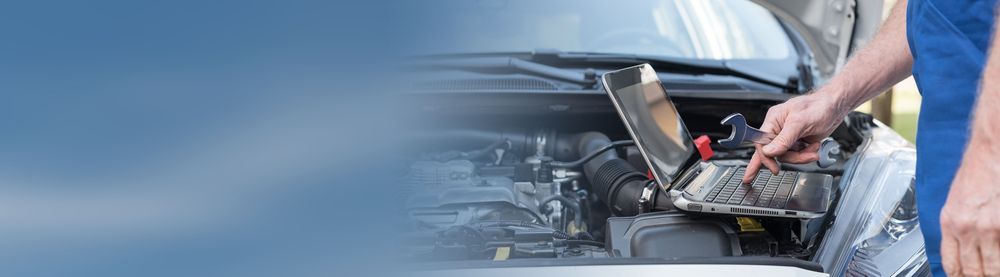 A Man is Using a Laptop While Working on the Engine of a Car — Hive Mobile Roadworthy in Pimpama, QLD