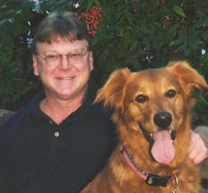 A man is standing next to a brown dog.