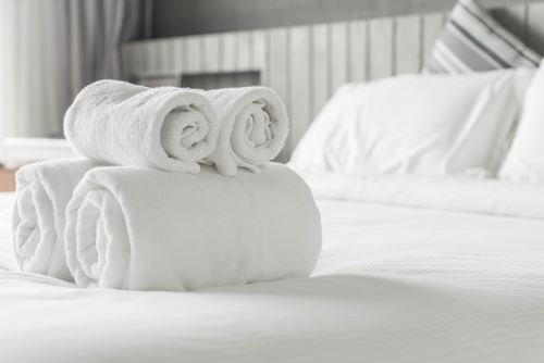 degli asciugamani arrotolati sopra ad un letto
