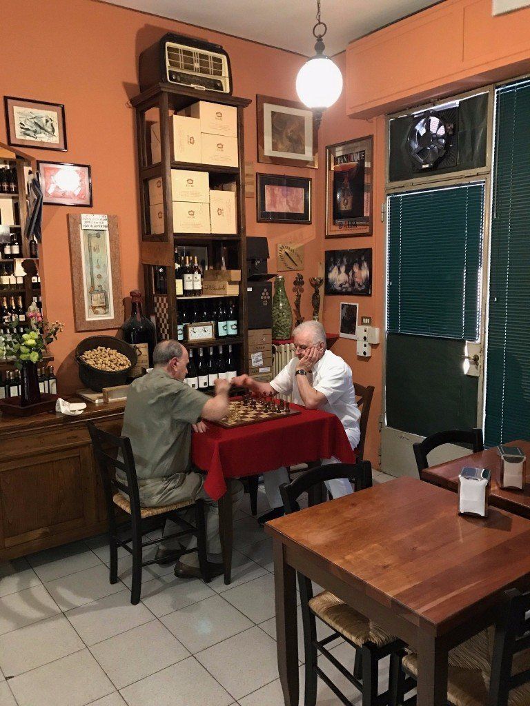 due anziani che giocano a scacchi nell'enoteca