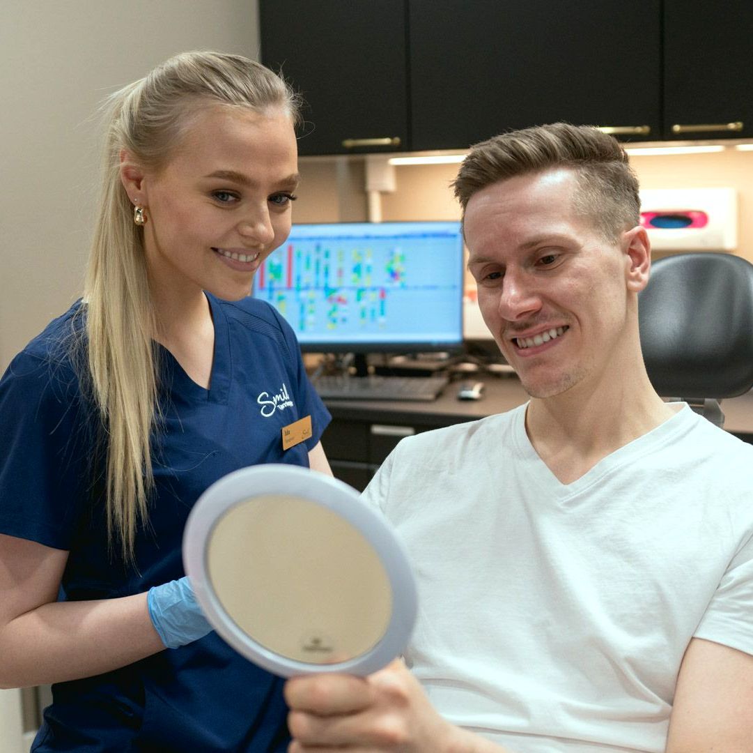 Tannlege Trine viser frem tenner til en pasient hos Smil Tannlegesenter i Oslo