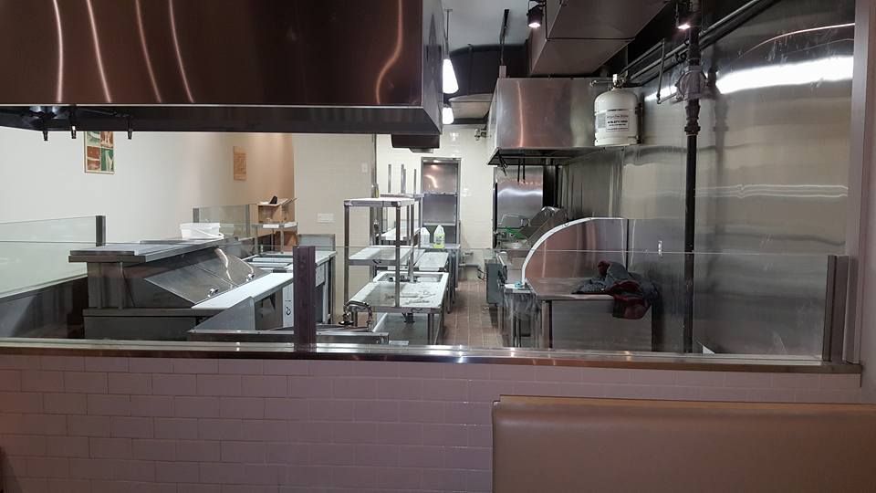 A kitchen with stainless steel appliances and a large window.