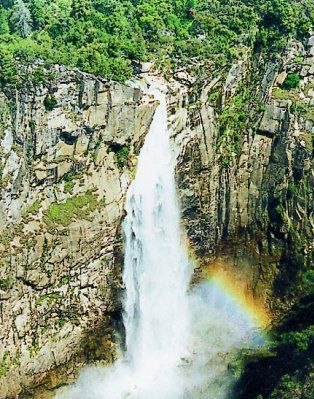 A waterfall with a rainbow in the middle of it