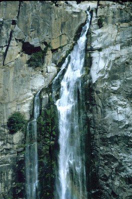 A waterfall is coming down the side of a rocky cliff.