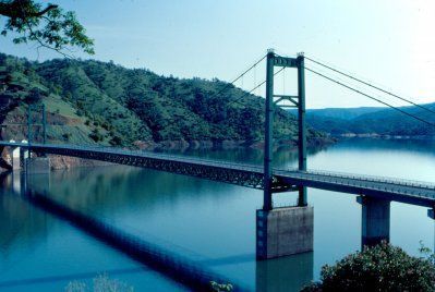 A bridge over a lake with mountains in the background.