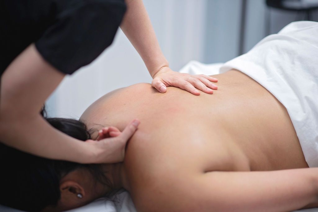 A person receiving a shoulder massage in a spa.