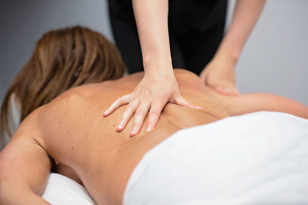 A woman is getting a massage on her back at a spa.