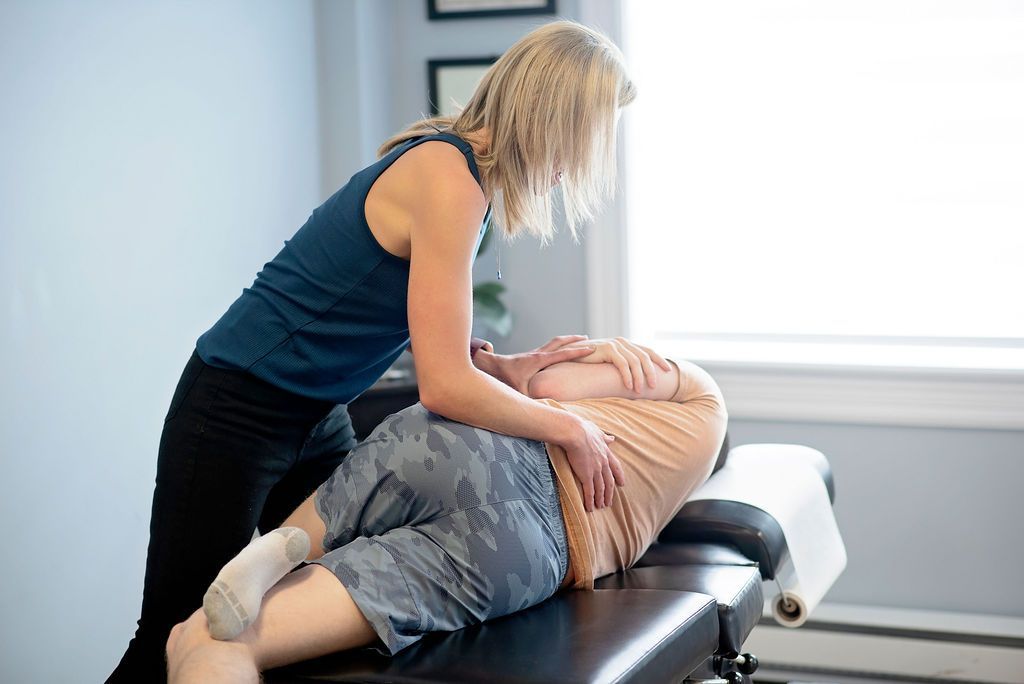 a woman in a blue tank top is giving a man a massage