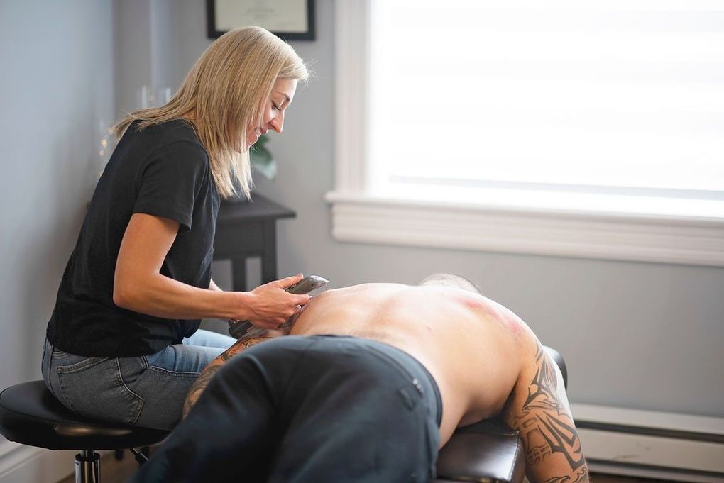 a woman is giving a man a massage on his back
