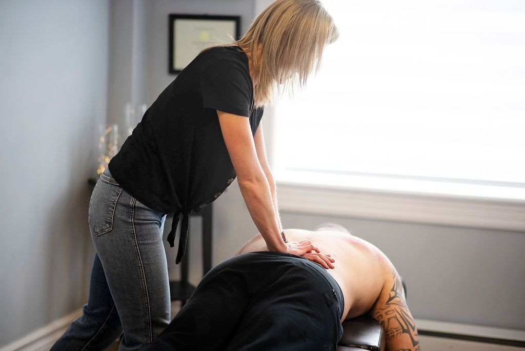 a woman in a black shirt is giving a man a massage