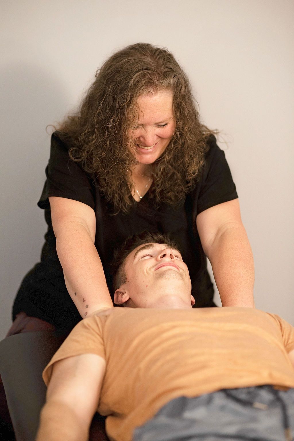 a woman is smiling while giving a man a massage