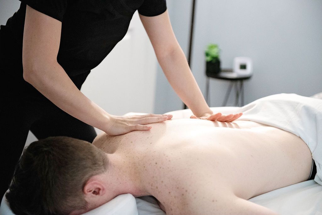 Massage therapist working on a client’s back on a massage table in a spa setting