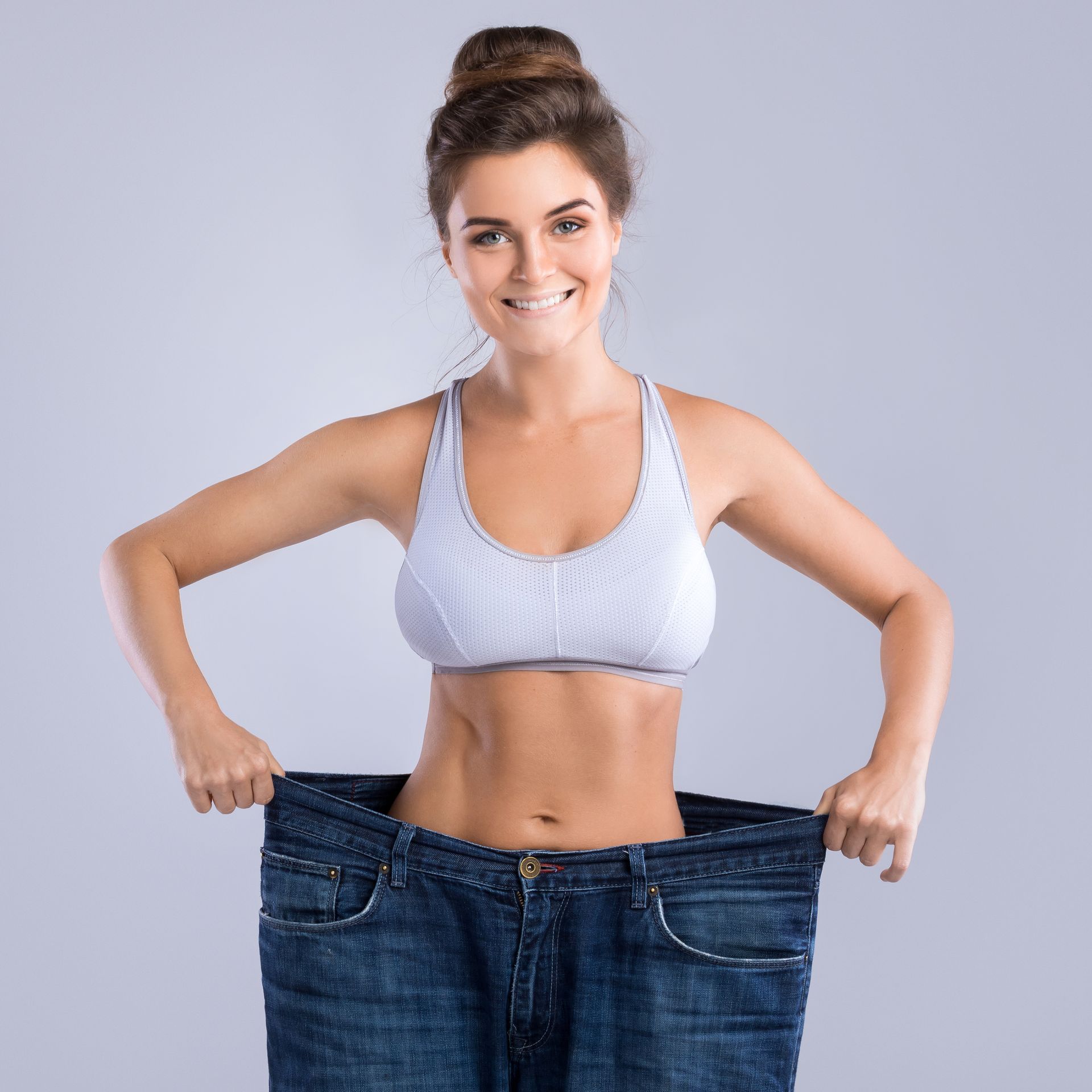 A woman is wearing a pair of very large jeans.