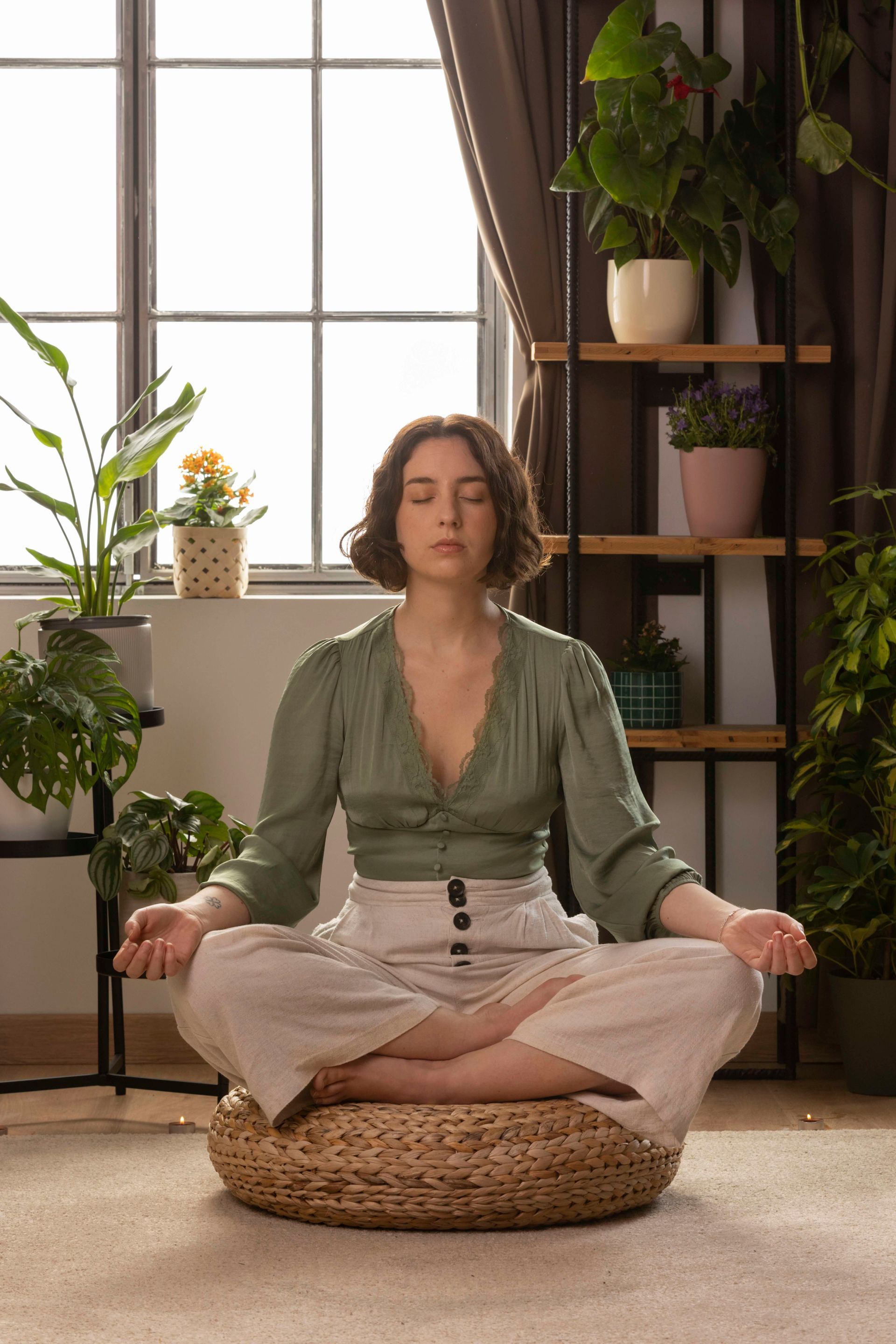 a woman sits in a lotus position with her eyes closed