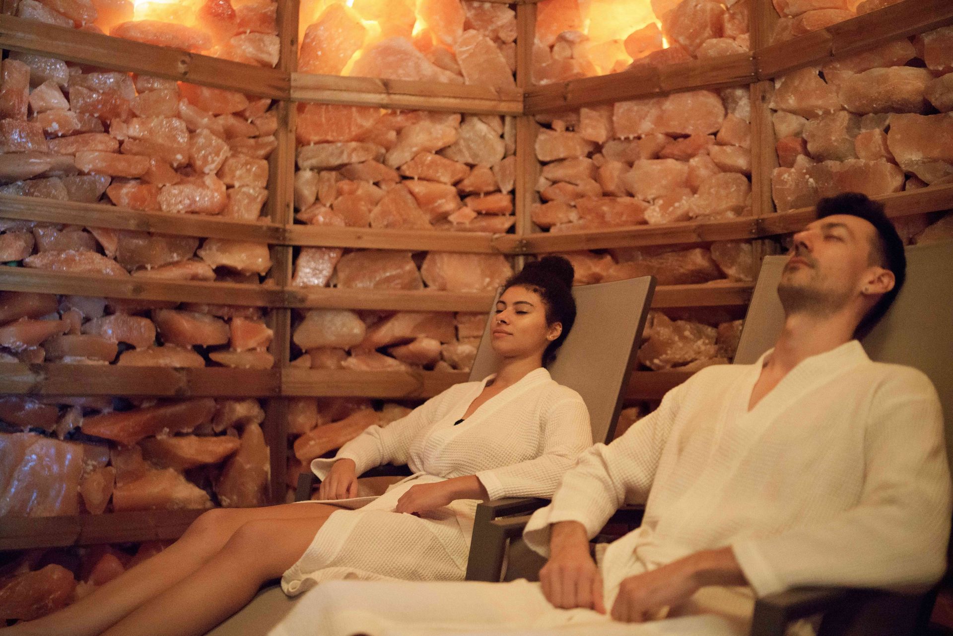 a man and a woman are laying in chairs in a room filled with rocks
