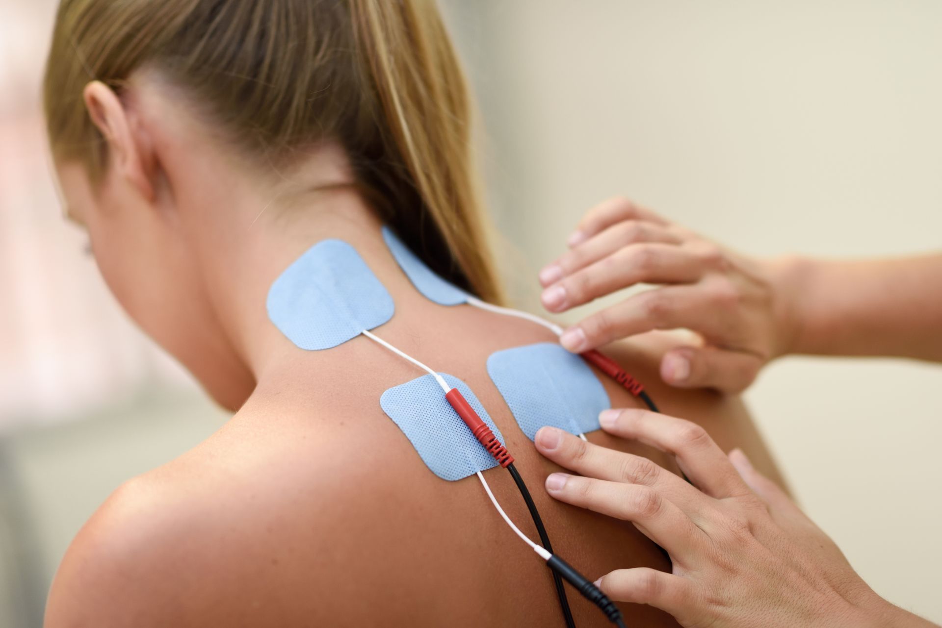 a woman is getting electrodes applied to her neck