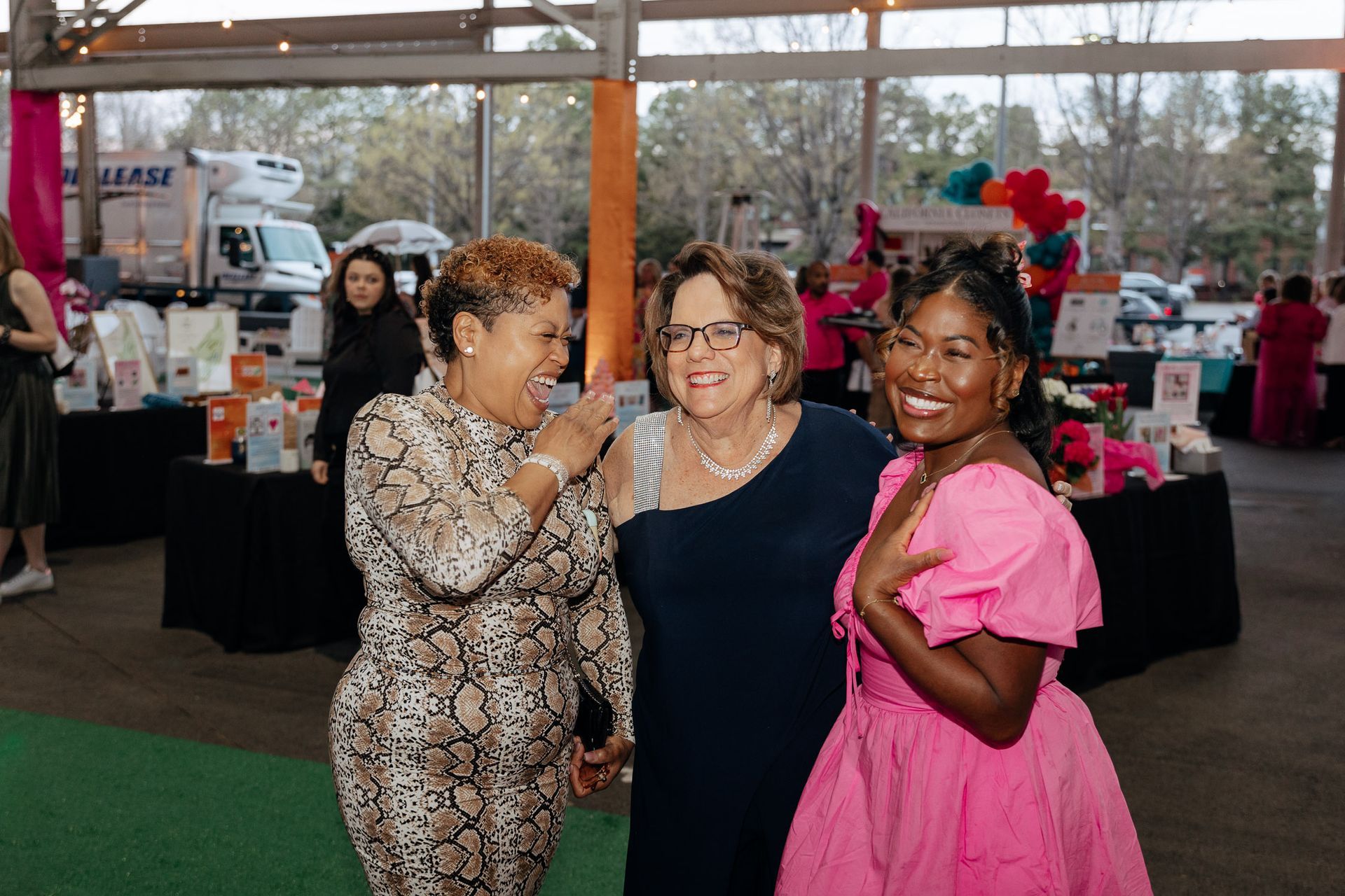 Three women are posing for a picture together at a party.
