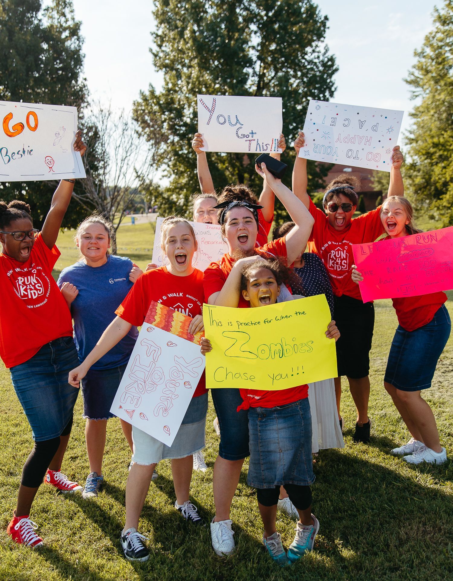 A group of people are holding up signs in a park