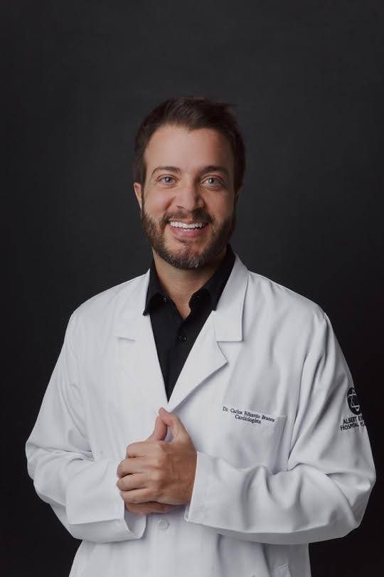 Homem de olhos e barba azuis, vestindo uma camisa preta, olhando diretamente para a câmera.