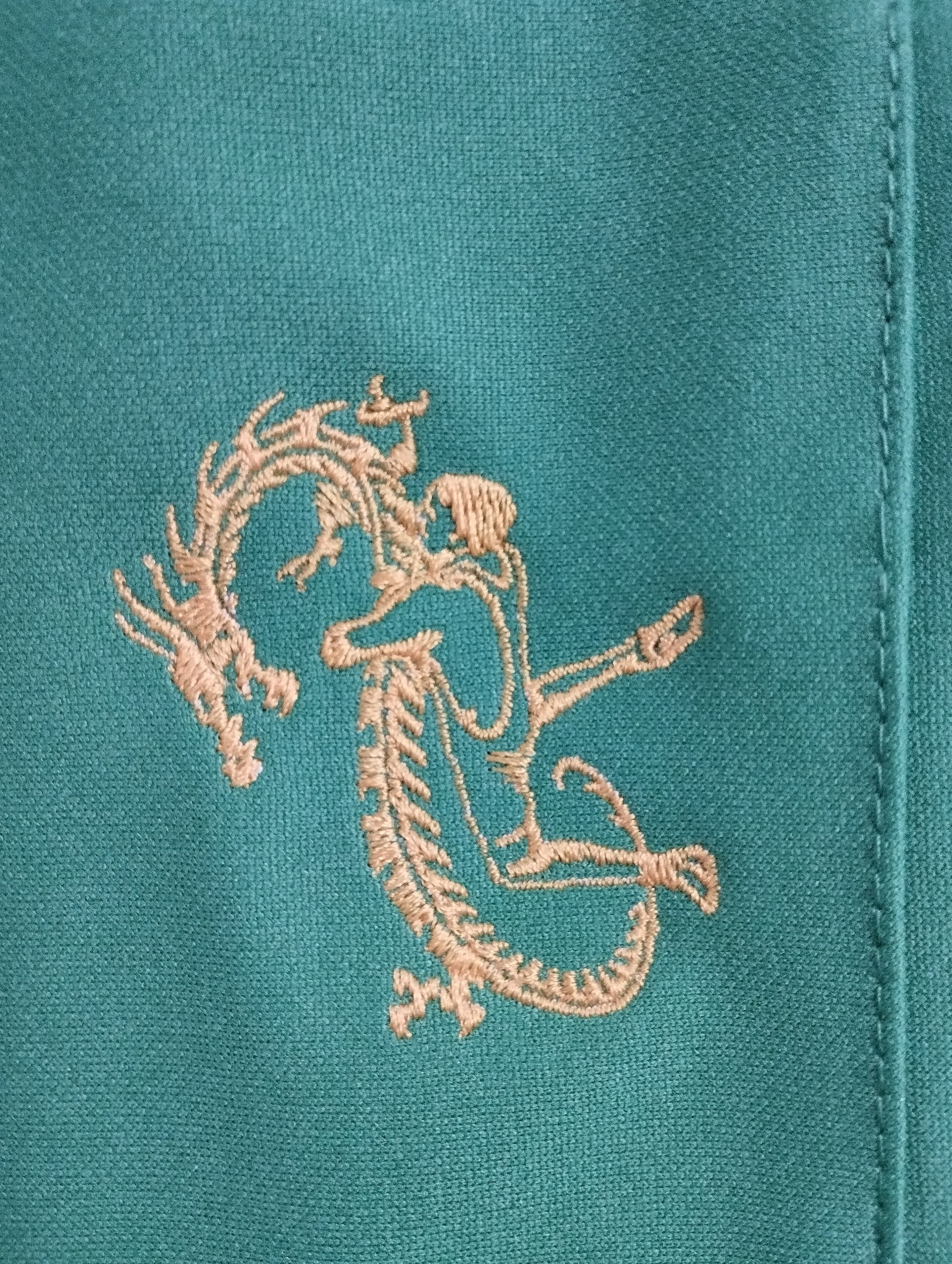 Primo piano di un asciugamano con un drago ricamato sopra.