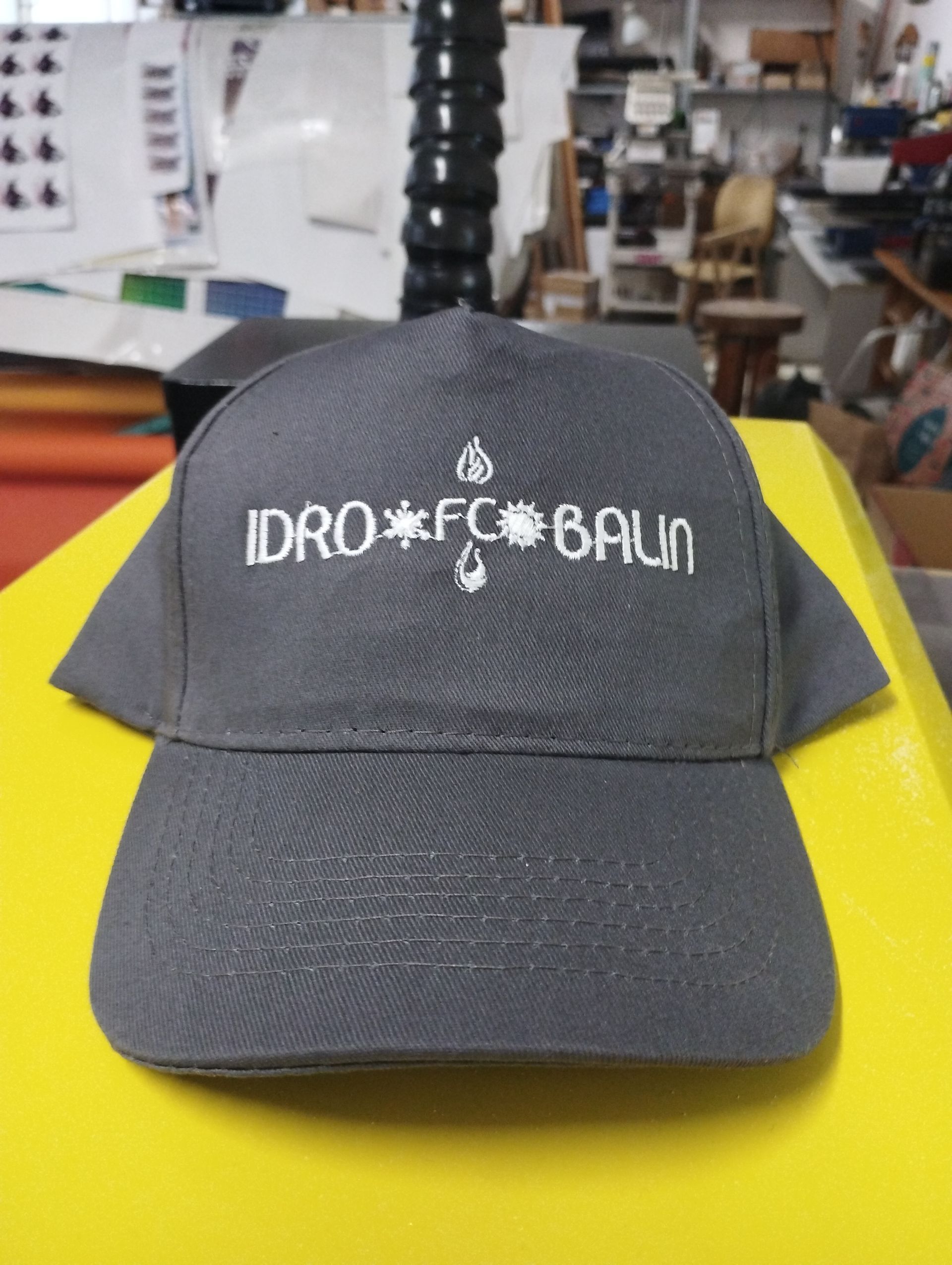Un berretto da baseball grigio con la parola idro sopra