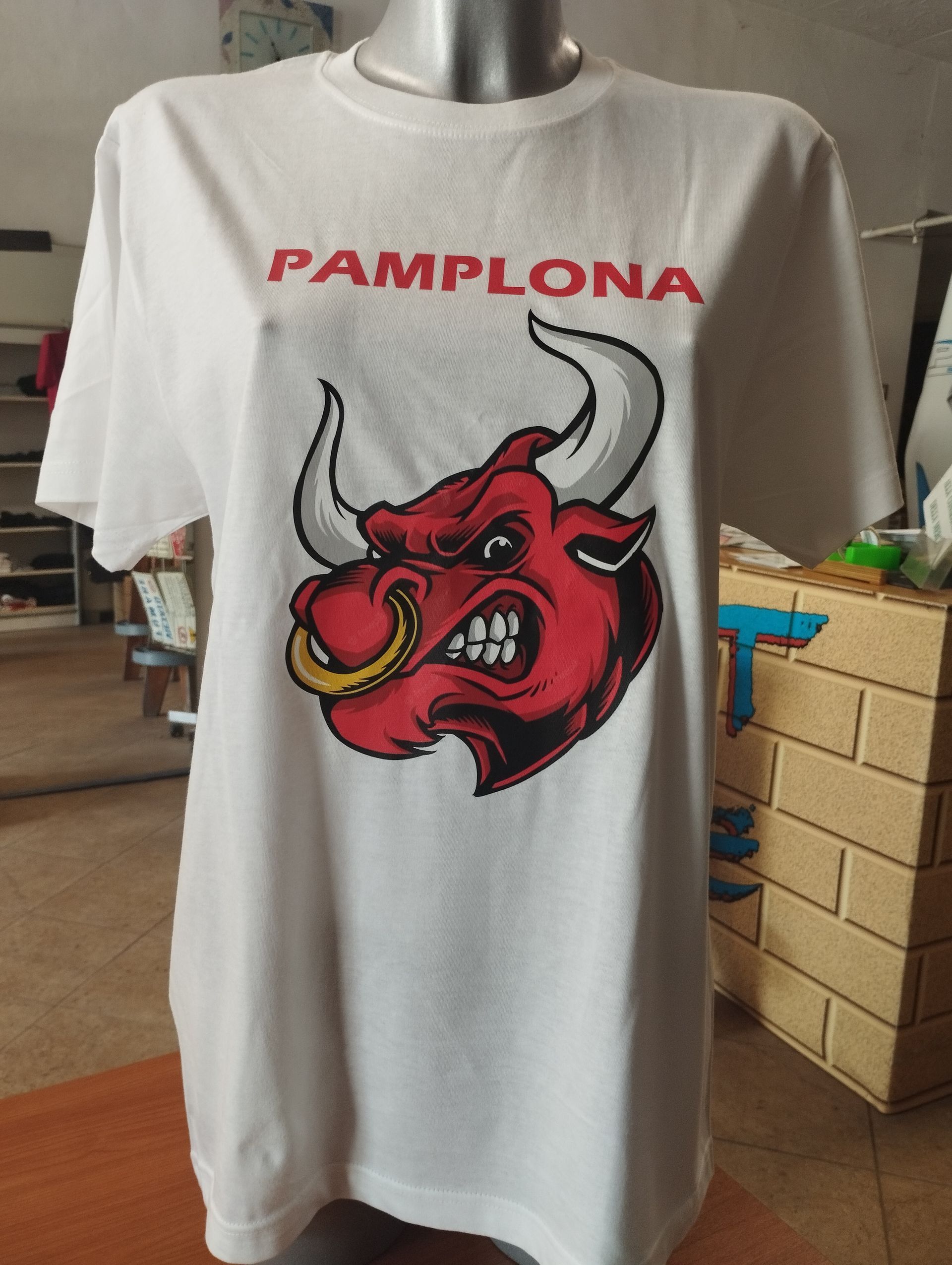 Una maglietta bianca di Pamplona con un toro sopra