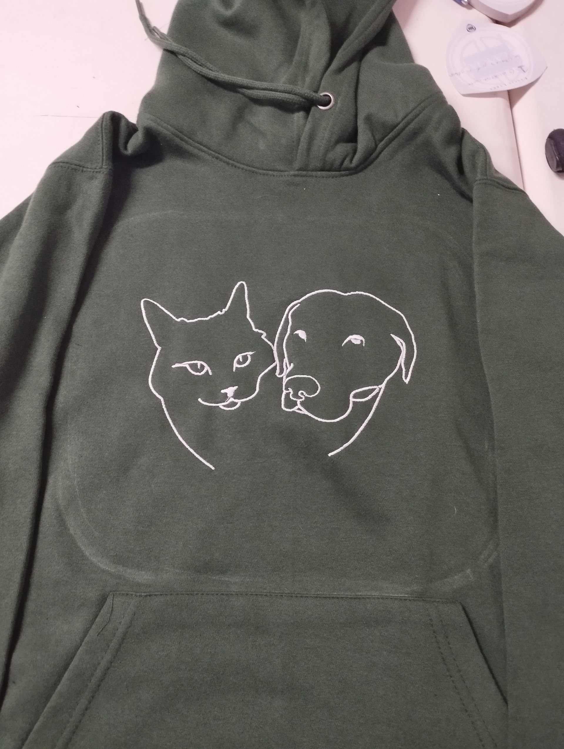 Una felpa verde con un gatto e un cane sopra
