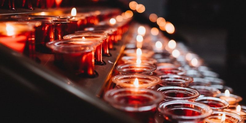 memorial candles in red glass holders creating a warm, peaceful atmosphere at a remembrance or funeral service.