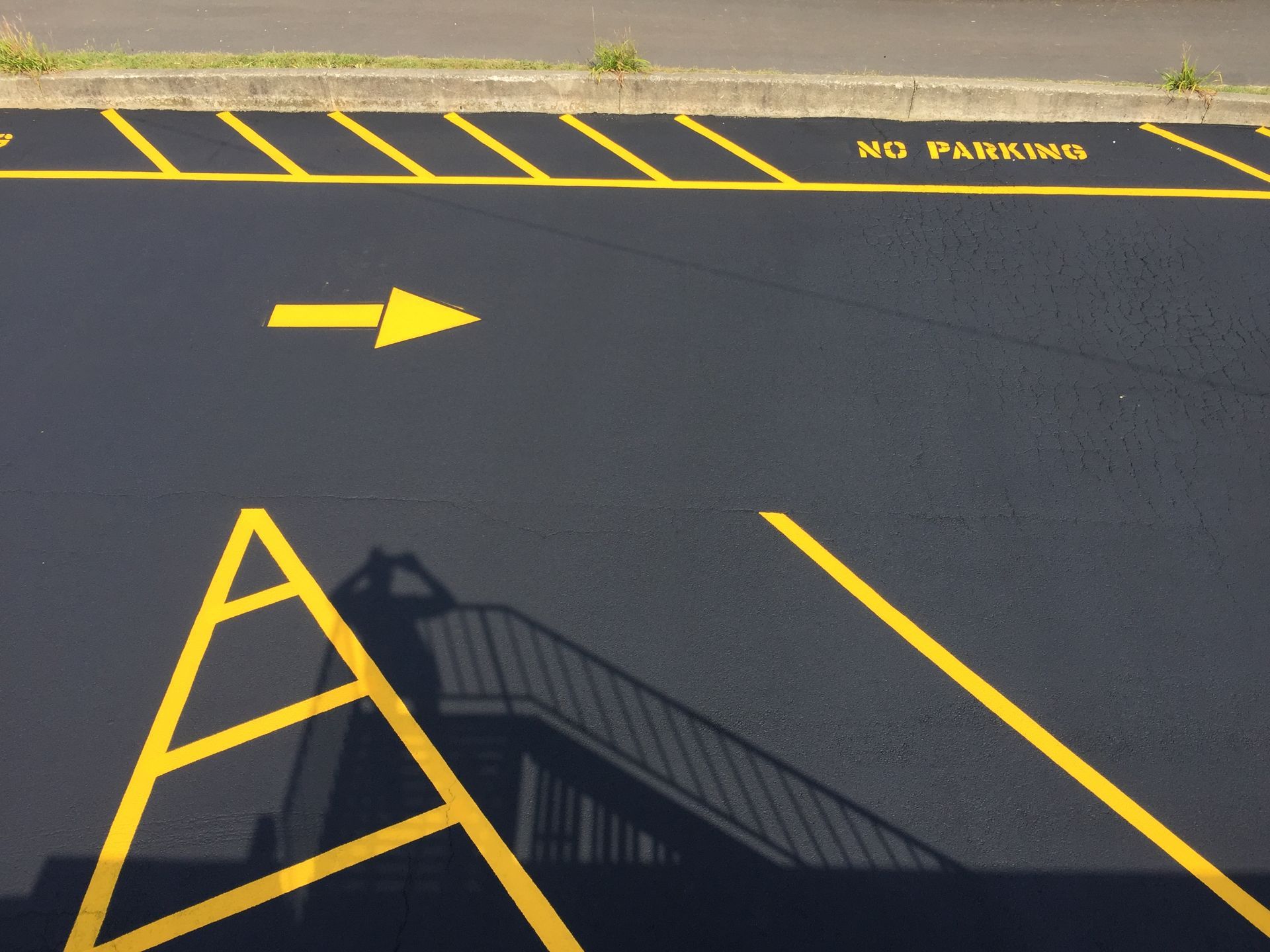 A parking lot with an arrow pointing to the right and a sign that says no parking