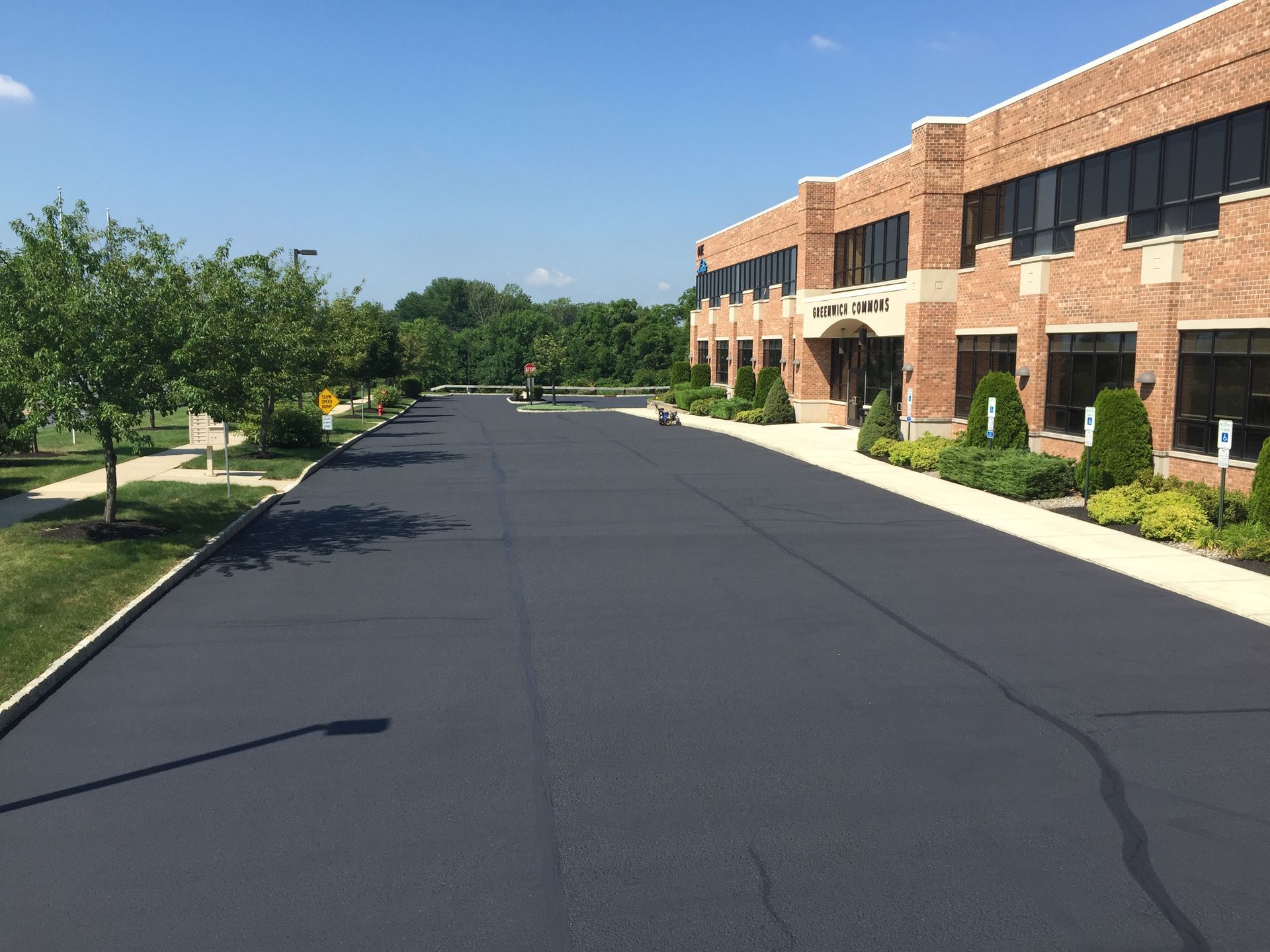 A large brick building with a paved driveway in front of it.
