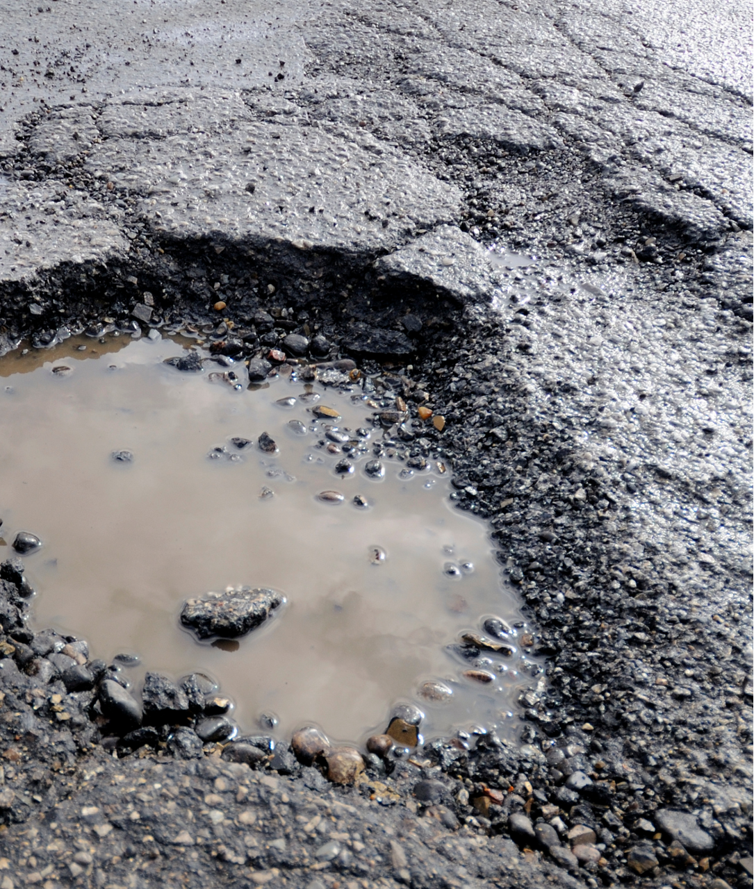 There is a puddle of water in the middle of the road.