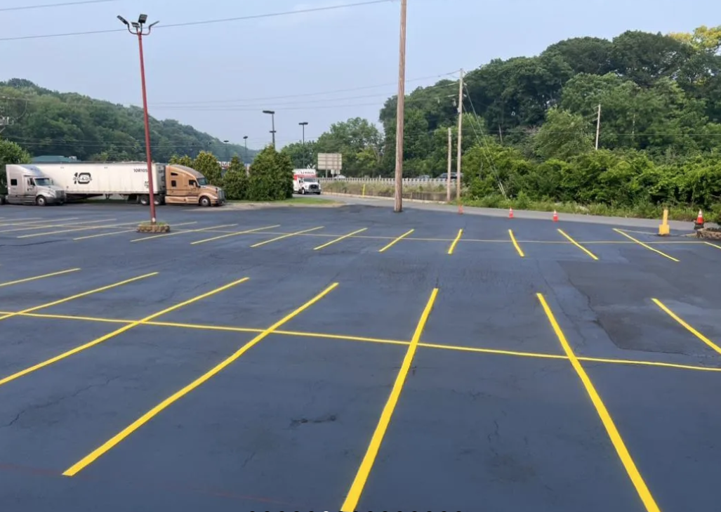 A parking lot with yellow lines and a truck in the background
