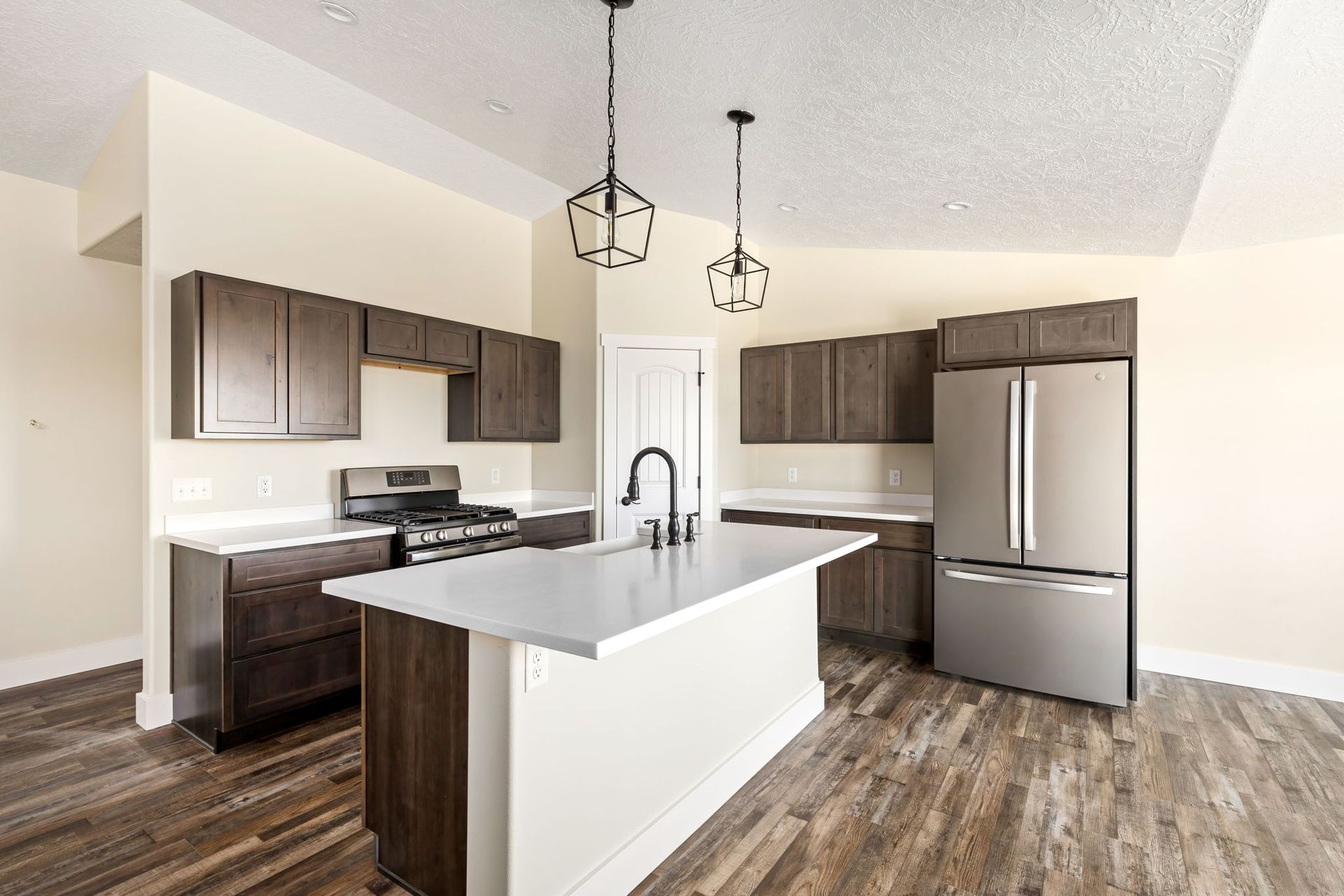 A kitchen with stainless steel appliances and wooden floors.