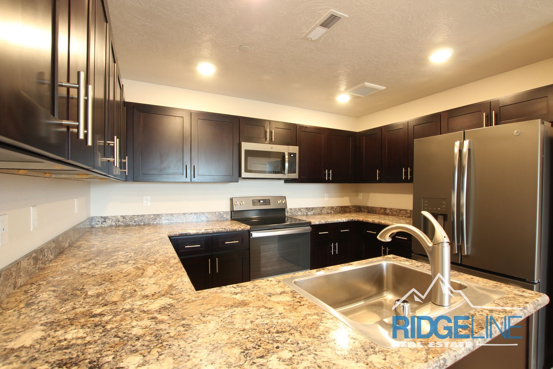 A kitchen with granite counter tops and stainless steel appliances