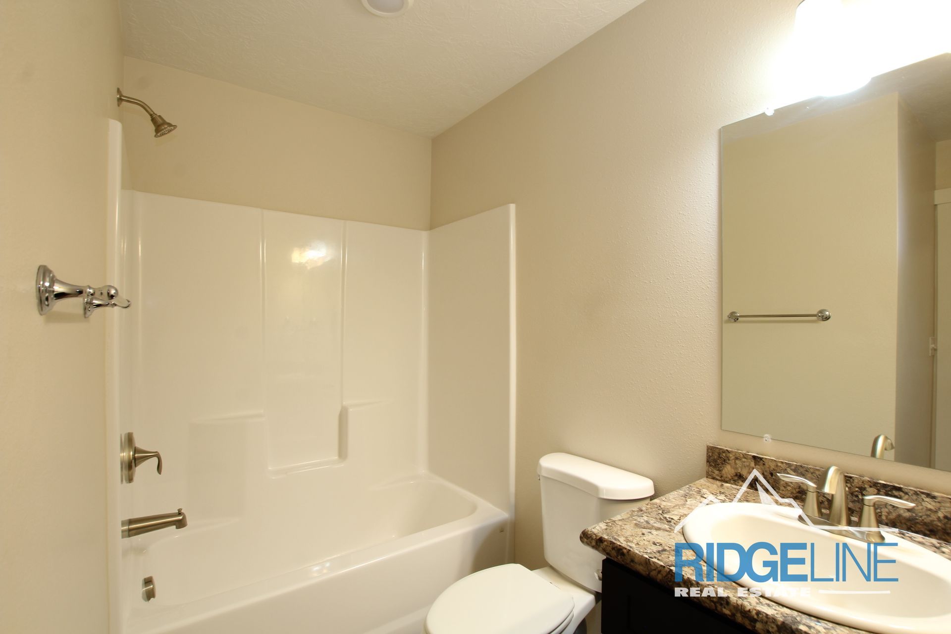 A bathroom with a tub , toilet , sink and mirror.