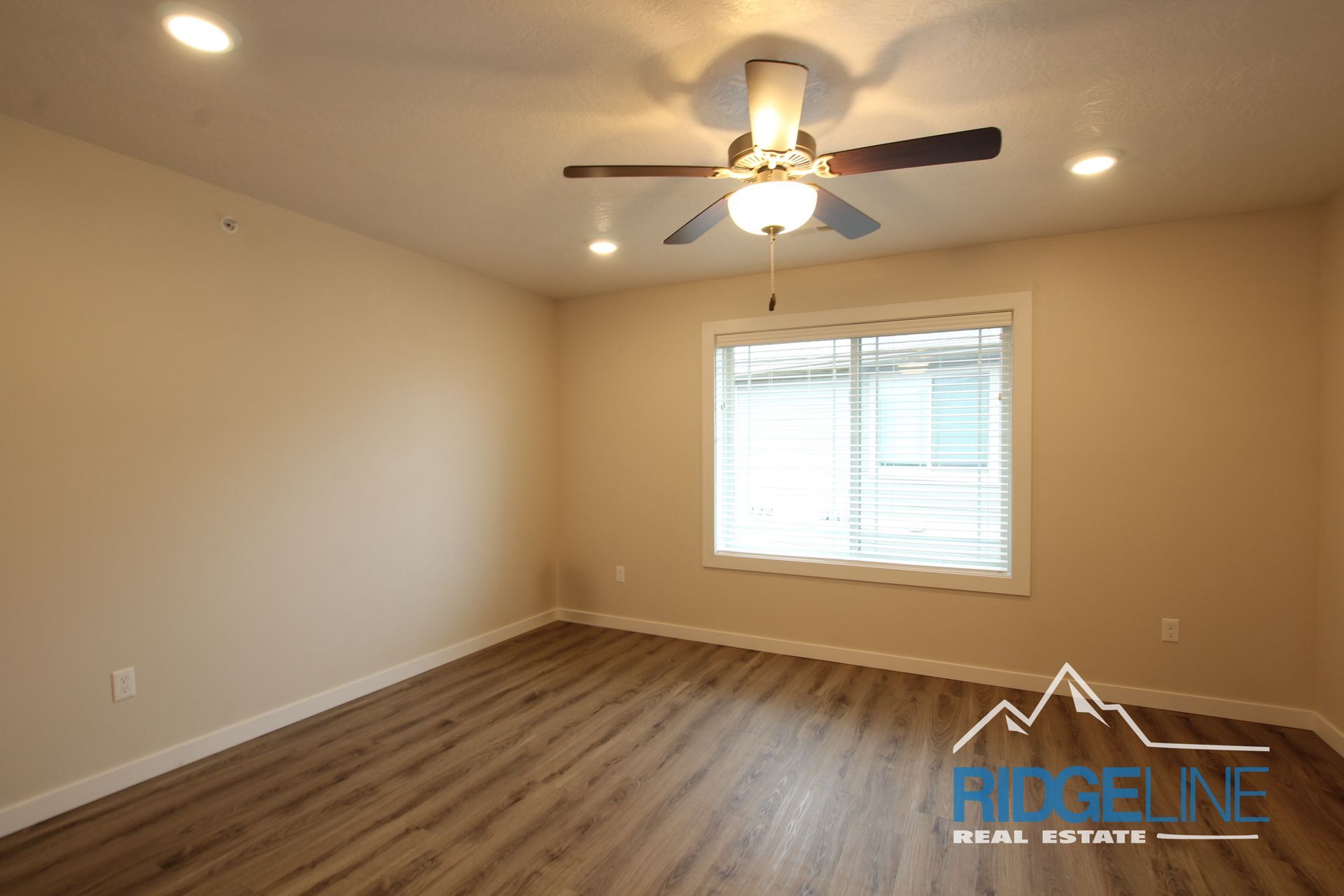 An empty room with a ceiling fan and a window