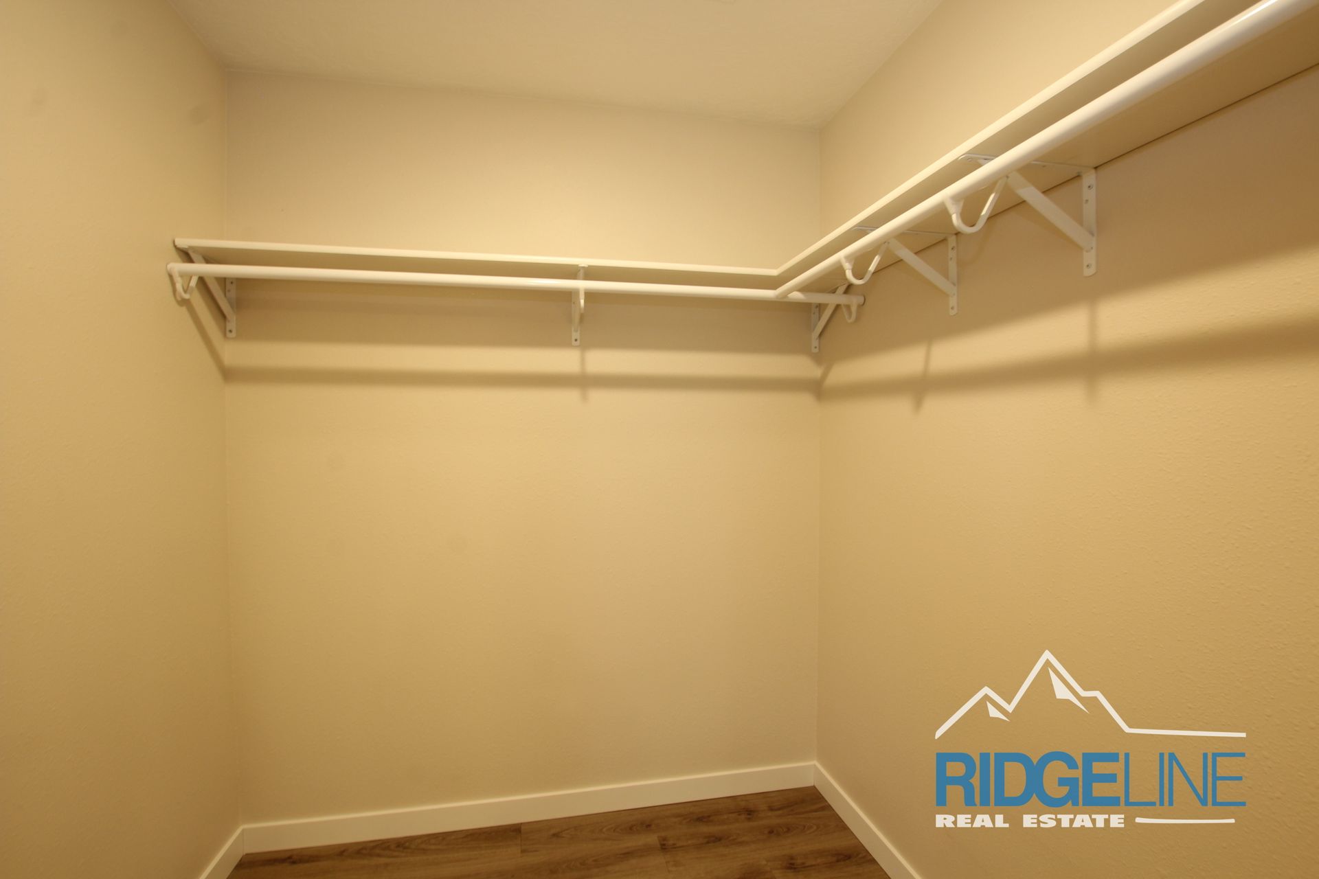 An empty walk in closet with ridgeline real estate written on the wall