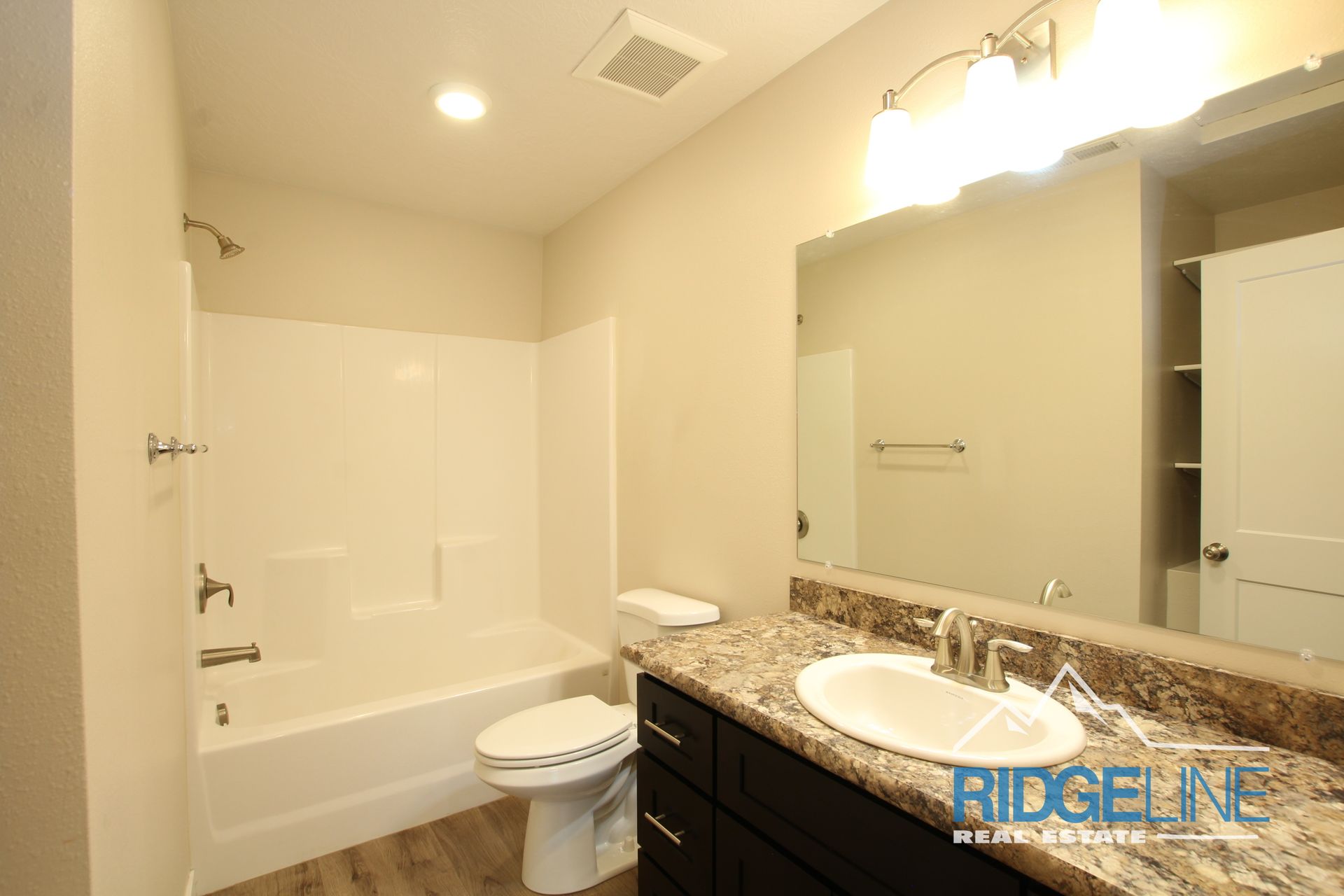 A bathroom with a sink , toilet , bathtub and mirror.