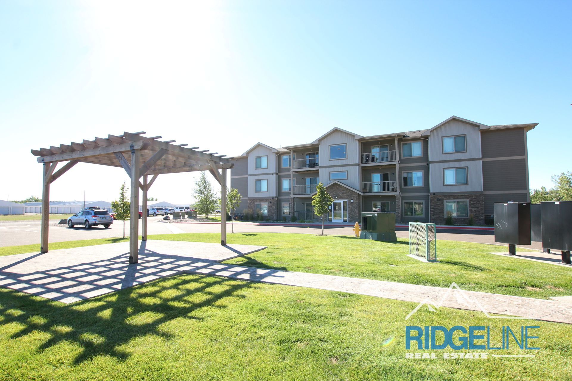 A large apartment building with a pergola in front of it