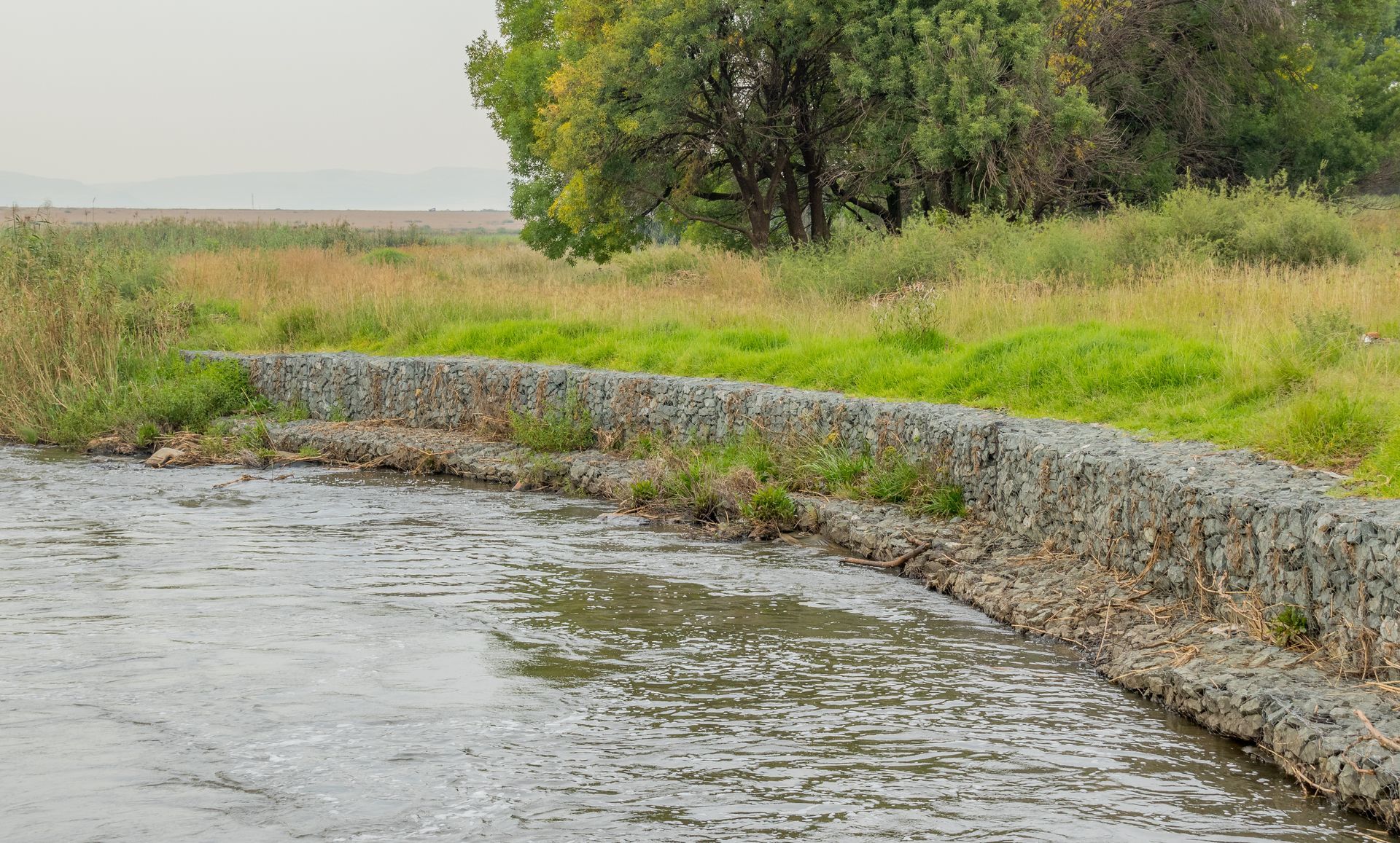 Gabion retaining walls to control erosion and flooding on the banks of a fast-flowing river.