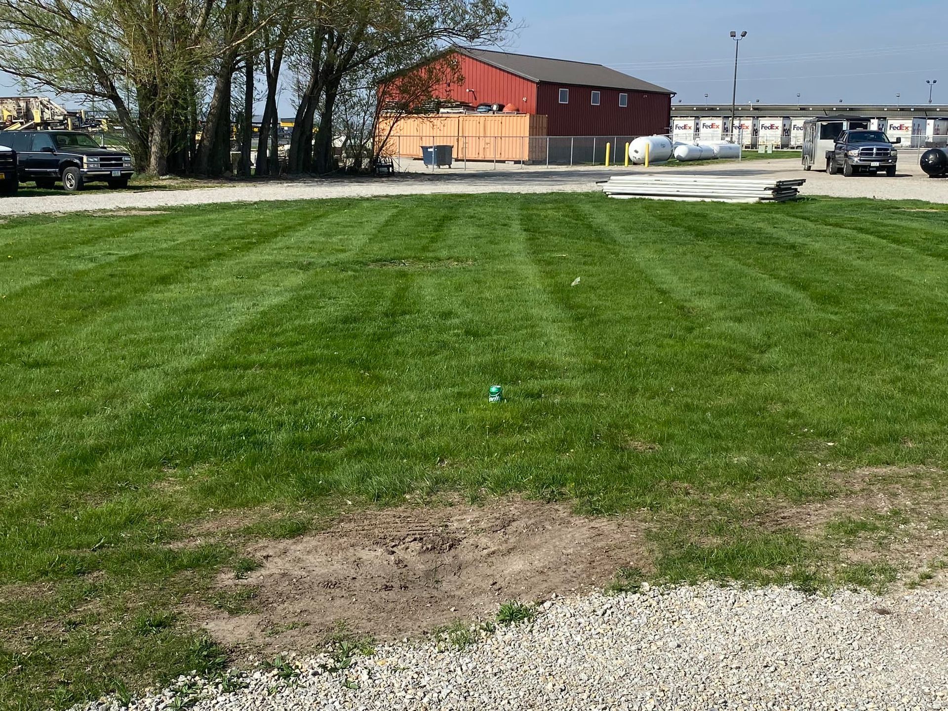 A lush green field with a red barn in the background.