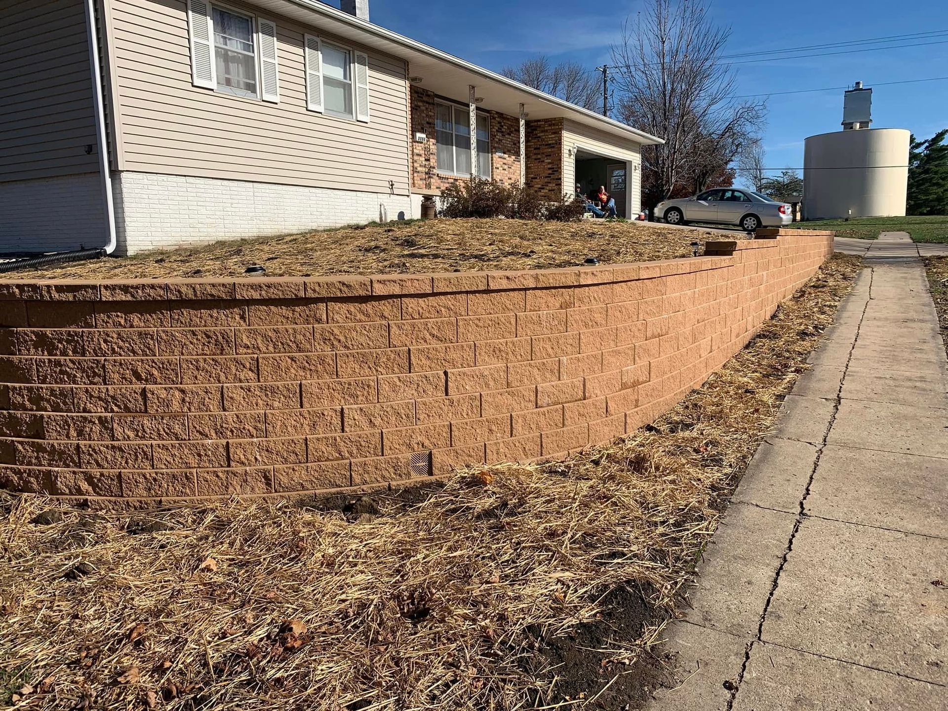There is a brick wall in front of a house.