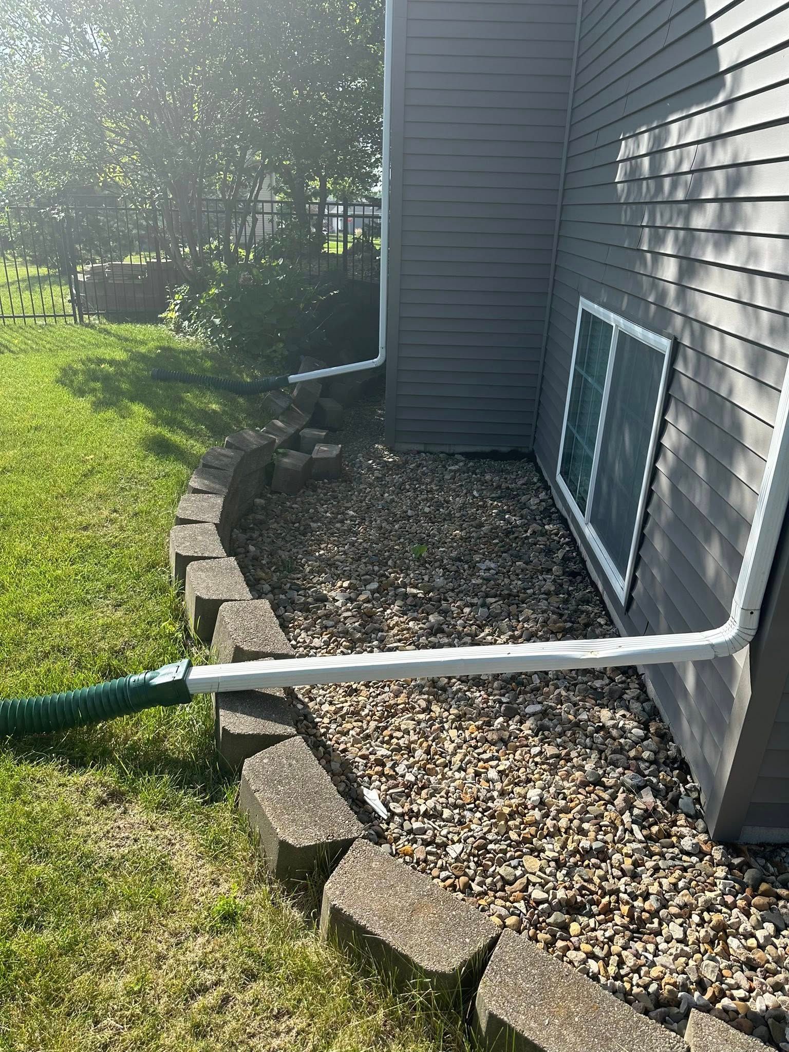 A drain pipe is connected to the side of a house.