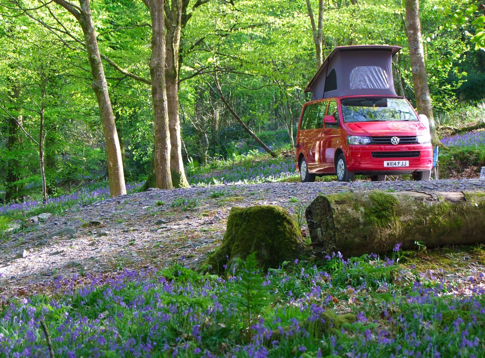 A white motorhome is driving down a mountain road