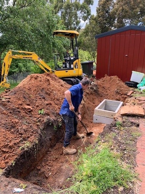 Air conditioner unit mounted on a green ivy-covered wall.