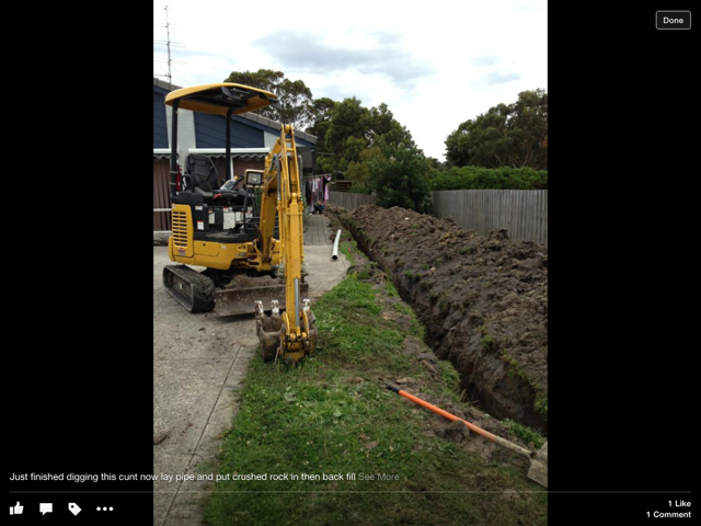 Heat pump water heater against a brick wall, with digital control panel.
