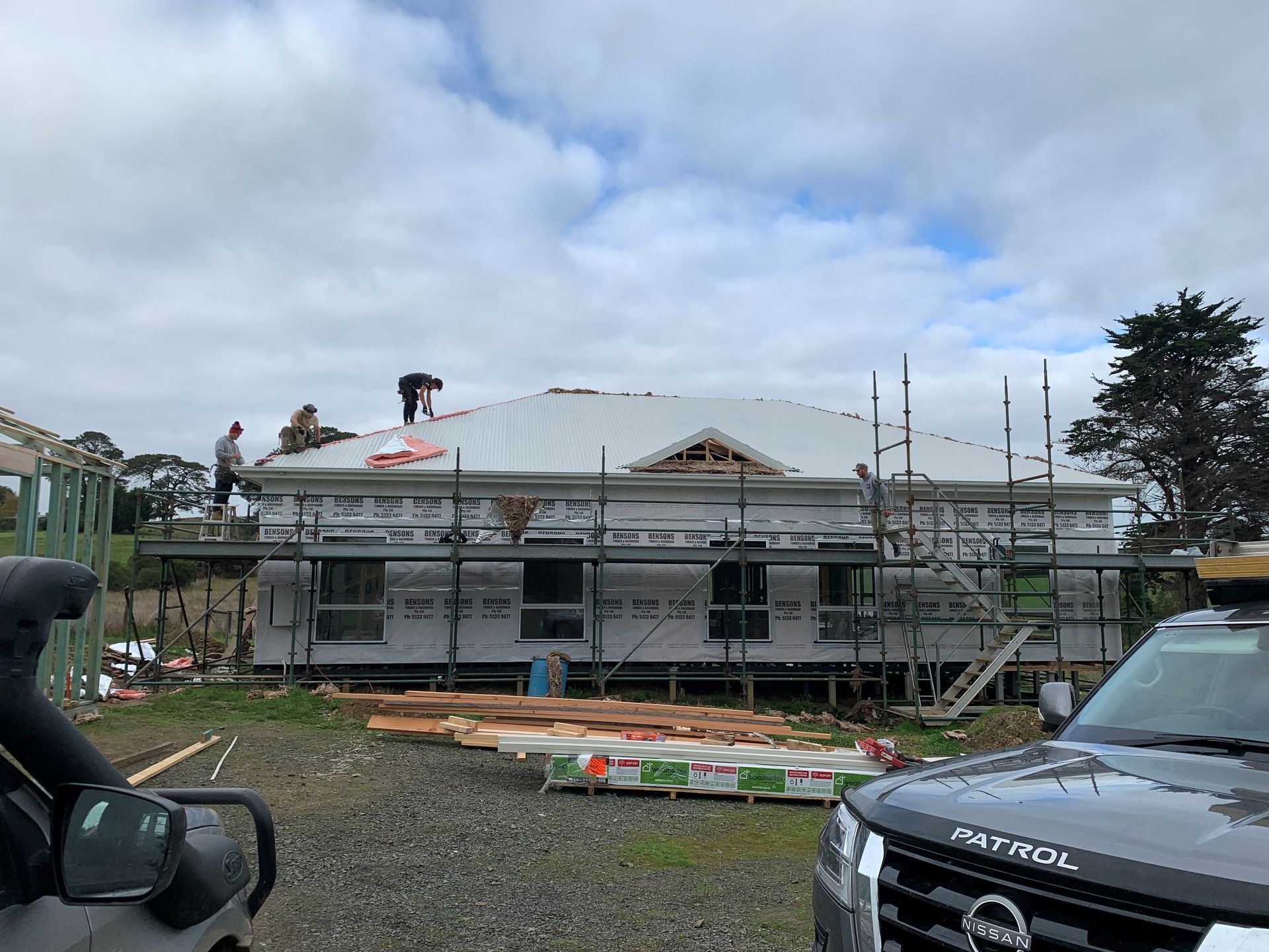 Close-up of four vertical metal panels in shades of green, silver, blue, and brown, showing a ridged texture.