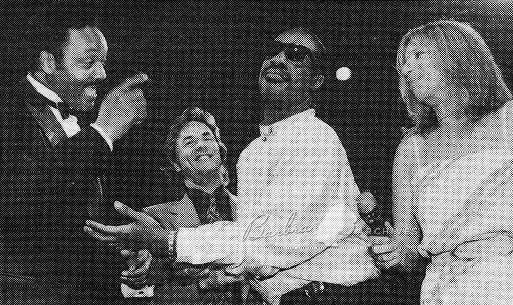 Jesse Jackson, Don Johnson, Stevie Wonder, and Barbra Streisand on stage at the Apollo.