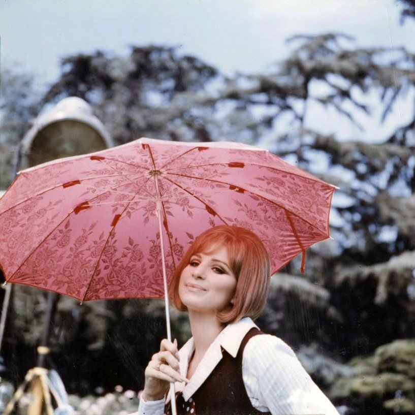Streisand on set with an umbrella.