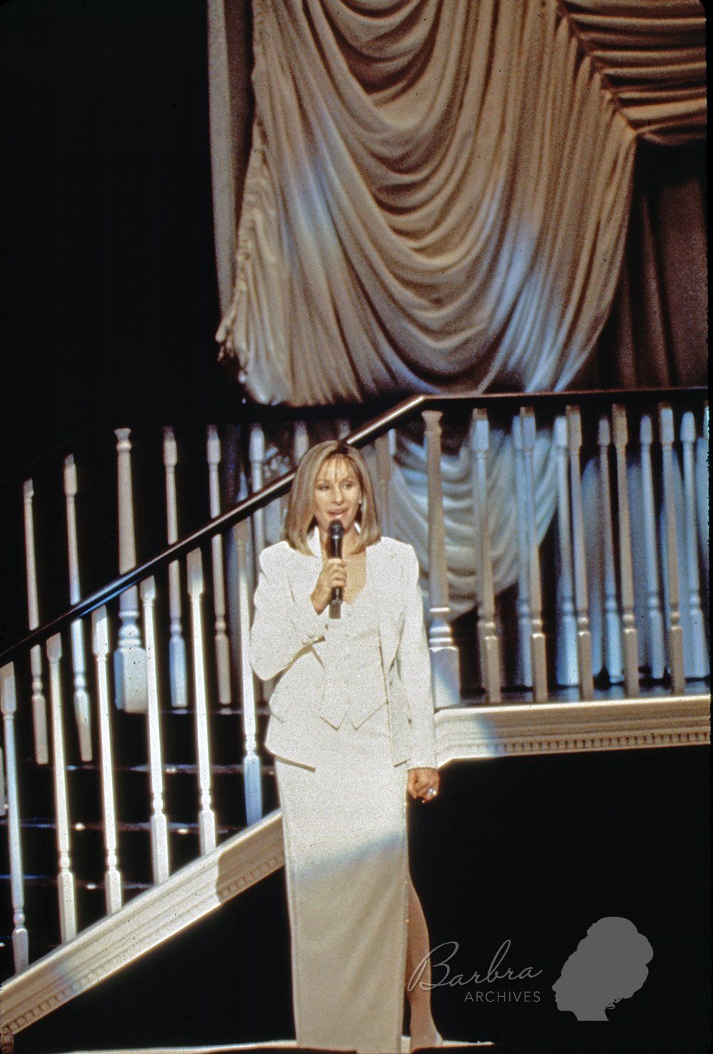 Barbra Streisand wearing off-white suit and skirt in the second act of her concert.